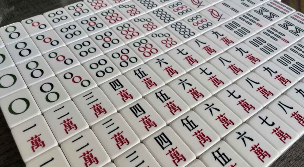 Full set of mahjong tiles set up next to each other in chronological order